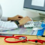 Dossier médical de santé au travail ouvert sur un bureau avec un stéthoscope, symbolisant l'analyse de la conformité médicale
